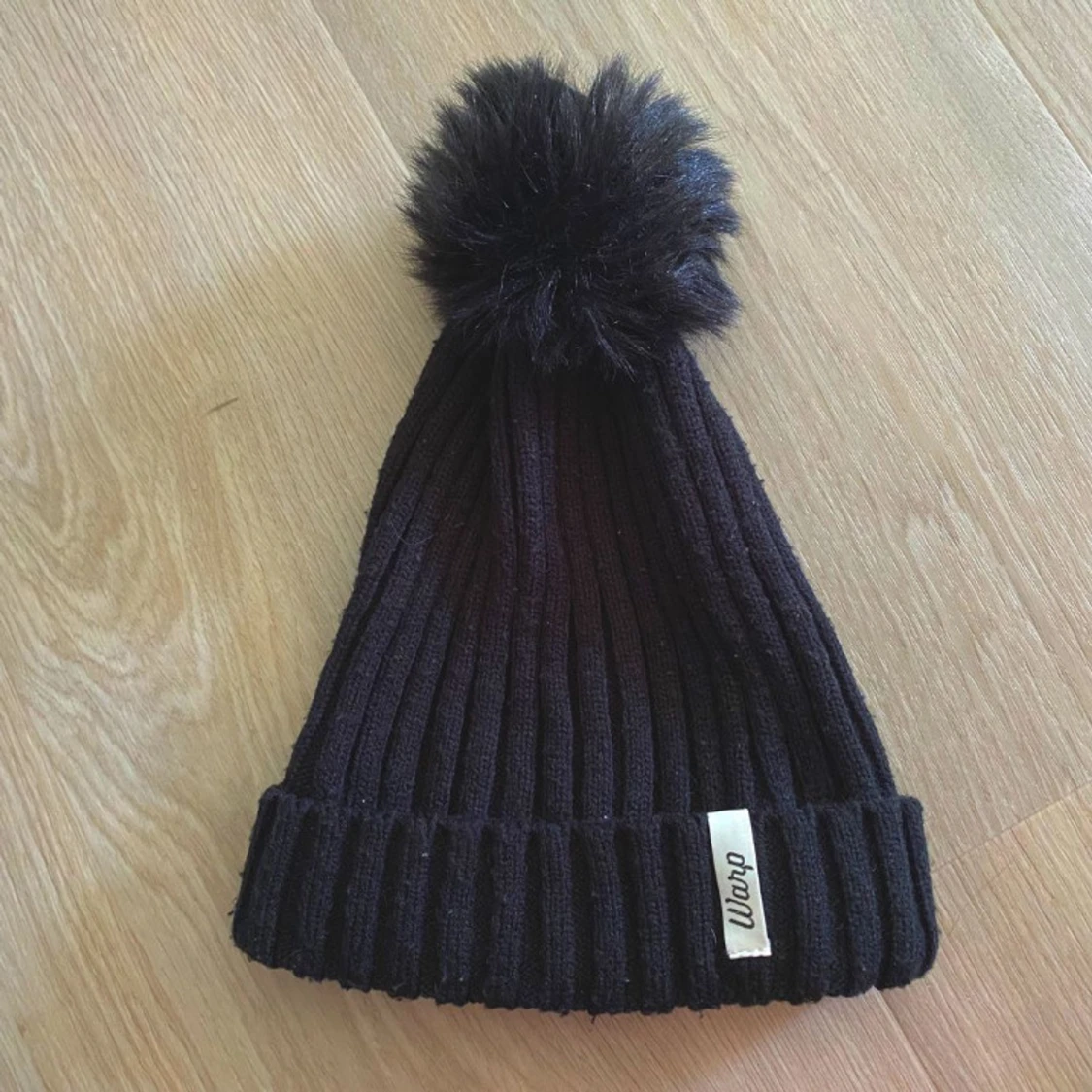 Svart ribbstickad mössa Warp med tofs