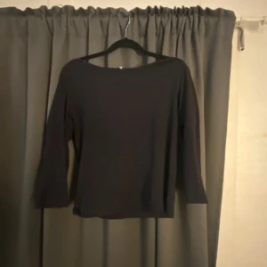 Svart långärmad topp med båtringning - En stilren svart topp med båtringad hals 