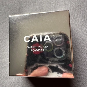 CAIA Wake Me Up Powder Banana - Wake Me Up Powder från CAIA i nyansen Banana är ett mjukt, transparent löspuder som ljusar upp och smälter in i huden. Perfekt för området runt ögonen och ger en lätt skimrig finish. Kommer i en snygg, spegelblank förpackning. Helt nytt oöppnat 