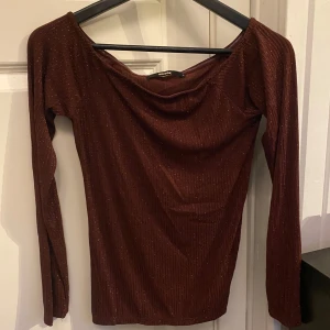 Glittrig festtopp - Säljer en superfin off shoulder topp från BikBok med ribbad struktur och glitter. 