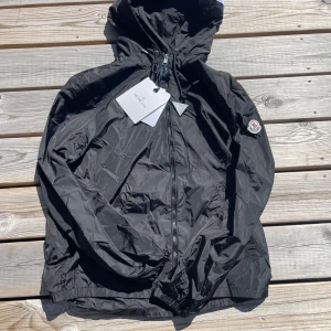 Moncler windbreaker  - Säljer min fräscha Moncler windbreaker. Den är väldigt skön och perfekt för hösten som kommer och de kalla sommar kvällarna. Den är i storlek M/2 men passar Small också. Den har ett litet hål vid vänster arm som knappast är synligt 