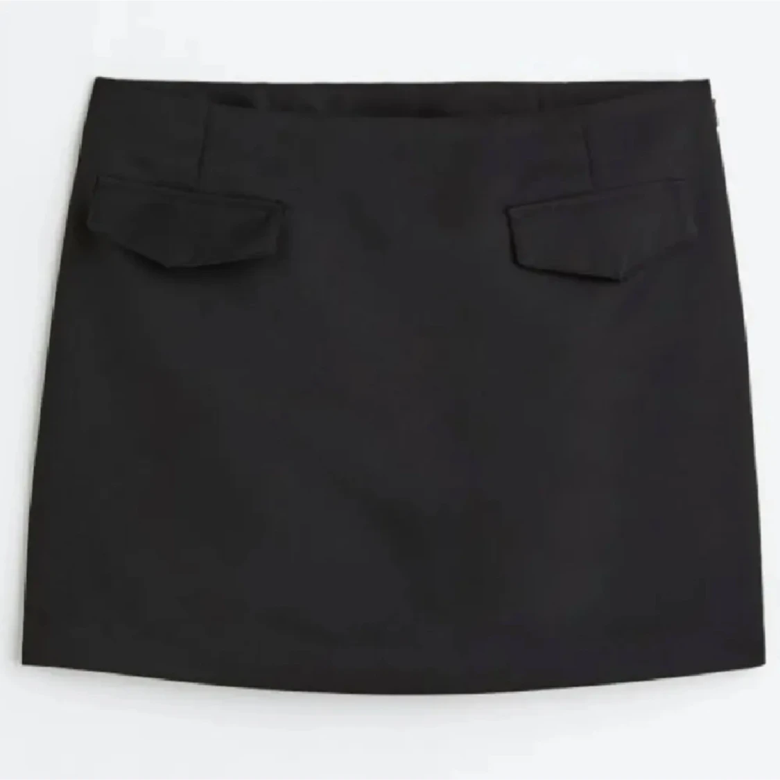 Svart kortkjol med fickdetaljer