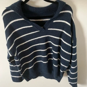 Randig mörkblå stickad tröja - Säljer en mysig stickad tröja i mörkblått med vita ränder. Sticks inte