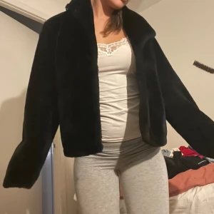 Svart pälsjacka med krage - Säljer en svart pälsjacka med klassisk krage och lång ärm. Jackan är mjuk och fluffig, perfekt för att hålla värmen och ge en lyxig vibe till din outfit. Modellen är rak och något croppad. Köpt för ca 650