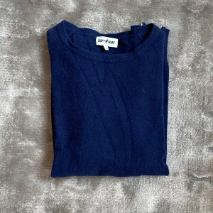 Mörkblå kashmirtröja från Soft Goat - Säljer en mörkblå långärmad kashmirtröja från Soft Goat. Tröjan har rund halsringning, ribbade muddar och en snygg guldfärgad dragkedja i sidan som detalj. Perfekt för dig som gillar stilrena och mjuka plagg. Nästiltill oanvänd har bara legat i garderoben. 