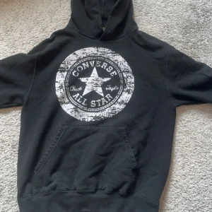 Svart Converse All Star hoodie - Säljer en svart hoodie från Converse med stort All Star-tryck på bröstet. Storlek M men skulle säga den passar S