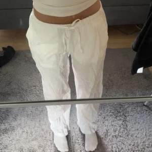 Vita linnebyxor från Gina Tricot - Säljer ett par vita linnebyxor från Gina Tricot i storlek XS. Byxorna har dragsko i midjan och är luftiga med rak passform, perfekta för varma dagar. Stilrena och enkla att matcha med olika toppar. köpta förra året för 500kr 