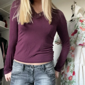 Mörklila långärmad topp med spets - Säljer en mörklila långärmad topp med v-ringning och spetsdetalj längs halsringningen. Toppen är figurnära och passar perfekt till jeans eller kjol. Mjuk och skön bomullskänsla💕💕💕