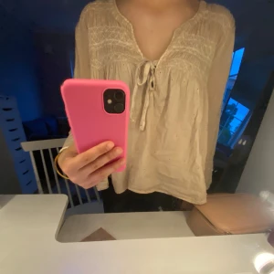 Beige blus med knyt framtill - Säljer en luftig beige blus med v-ringning och knyt framtill. Blusen har 3/4 ärmar och fina broderade detaljer upptill. Passar s-m, Pris är diskuterbart 💕