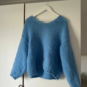 Blå stickad tröja från Vero Moda - Mysig blå stickad tröja från Vero Moda med lös passform och rund halsringning. Perfekt för att hålla sig varm under kyliga dagar. Enkel och stilren design som är lätt att matcha med olika outfits.