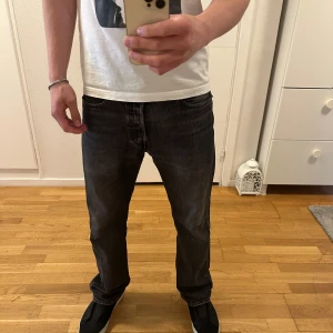 Levi's 501 svarta jeans 32 32 - Säljer ett par klassiska svarta Levi's 501 jeans i storlek W32 L32. Jeansen har rak passform, fem fickor och knappgylf. Perfekta till dig som gillar tidlös stil och vill ha ett par jeans som funkar till det mesta.