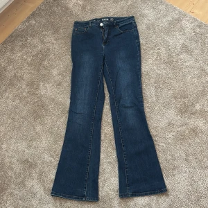 Mörkblå bootcut jeansbyxor från Denim 1953 - Mörkblå jeansbyxor från Denim 1953 i modellen Susan. Byxorna har klassisk femficksdesign, normal passform och bootcut-ben. Perfekta för dig som gillar en tidlös jeansstil med lite utsvängda ben. Storlek 40. Jag säljer dom då de blivit för små. Precis som nya- aldrig använda🩷 skriv till mig för mer info🫶🏻💞