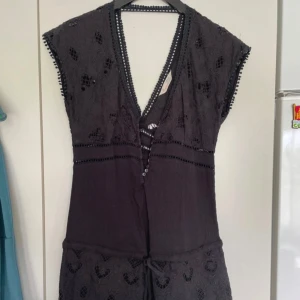 Svart spetsjumpsuit från Odd Molly - Supersnygg svart jumpsuit från Odd Molly med v-ringning och fina spetsdetaljer. jumpsuiteb har korta ärmar, knappar framtill och broderade mönster. Perfekt för dig som gillar en feminin och unik stil.