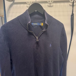 Mörkblå tröja med dragkedja från Polo Ralph Lauren - Säljer en mörklblå halfzip från Polo Ralph Lauren. Skicket är väldigt bra och storleken är S