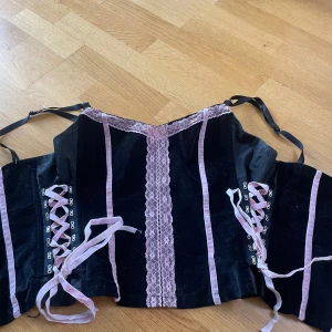 svart rosa korsett - gullig korsett köpt på second hand i somras men endast använd två gånger. vet inte vilken storlek det är men den går att justera i axelbanden och i midjan med banden. priset kan alltid diskuteras ❤️