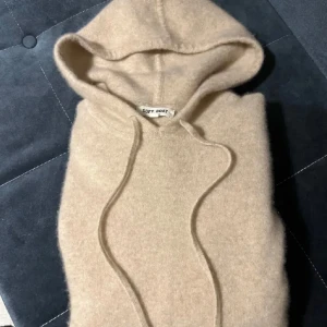 Beige hoodie från Soft Goat - Säljer en supermjuk beige hoodie från Soft Goat. Perfekt för kyliga dagar med sin mysiga huva och långa ärmar. Den har en klassisk design med dragsko i huvan. Nypris 2600kr. Kontakta mig vid frågor