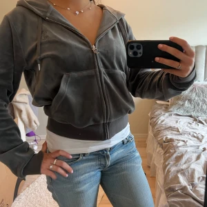 Juicy Couture kofta - Säljer en mörkgrå kofta från Juicy Couture med dragkedja och huva. Perfekt för en avslappnad och trendig look.💗är i storlek L men passar xs/s