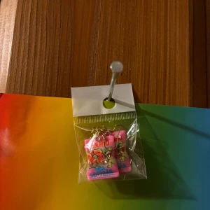 Färgglada rosa örhängen med motiv - Säljer ett par unika örhängen i rosa med färgglada motiv och detaljer. Perfekta för dig som vill sticka ut och addera lite färg till din stil. Kommer i förpackning och är redo att användas direkt.