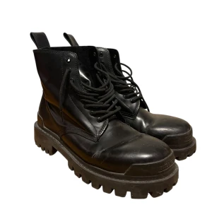Striker boots  - Säljer ett par svarta boots med kraftig sula och snörning. Skorna har rund tå och är tillverkade i skinn. Perfekta för dig som vill ha en chunky och stilen look. 