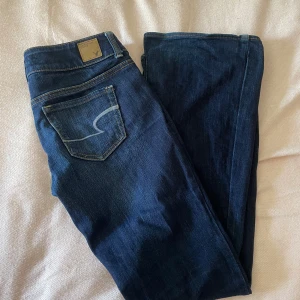 Lågmidjade bootcut jeans från American Eagle - Låtmidjade bootcut jeans från American Eagle. Fint skick och använda fåtal gånger. Står ingen storlek, men passar mig som är 166 och som brukar ha storlek XS-S. Skriv om ni vill ha mått. Skriv för frågor/ funderingar/ fler bilder. Priset är alltid diskuterbart!💕