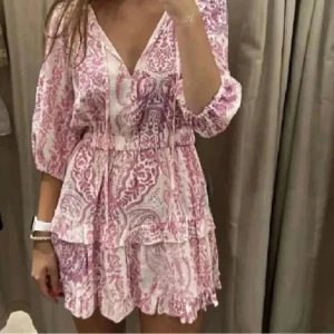 Rosa mönster Zara klänning  - Jättefin populär klänning från Zara, jättefint rosa och vitt mönster. Den är lite sydd där framme men absolut inget som man tänker på. Storlek M men passar S. Lägg prisförslag🩷
