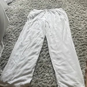 Vita vida linnebyxor från Gina Tricot - Ganska korta i längden så skriv om ni vill ha mått❤️Säljer ett par fräscha vita linnebyxor från Gina Tricot i storlek S. Byxorna har elastisk midja med snörning och ett avslappnat, wide fit. Perfekta för chill dagar eller när du vill ha en clean och luftig look.