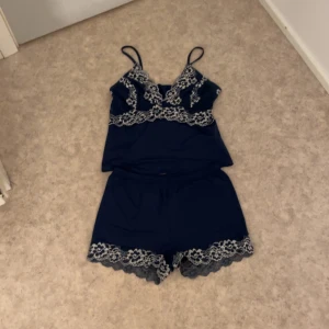 Marinblå linnetopp och shorts med spetsdetaljer - Snygg marinblå linnetopp och shorts. Perfekt för dig som gillar en feminin och stilren look. Detta köps ihop! 