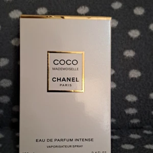 Chanel Coco Mademoiselle EdP Intense 100ml - Chanel Coco Mademoiselle Eau de Parfum Intense i 100 ml flaska. Parfymen kommer i en elegant, fyrkantig glasflaska med guld- och vitdetaljer samt en genomskinlig kork. Doften är ikonisk och lyxig, perfekt för dig som gillar exklusiva parfymer.