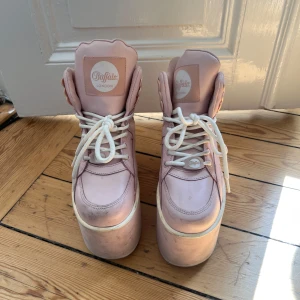 Buffalo London rosa platåsneakers - De ikoniska Rebecca & Fiona skorna 🤩 Buffalo London sneakers i ljusrosa med rejäl platåsula. Klassisk chunky 90-talsstil med vita snören och rundad tå.