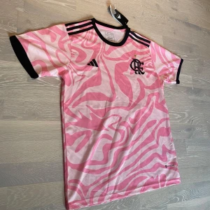 Rosa Flamengo T-shirt  - Säljer en jätte fett rosa Flamengo fotbollströja. Den är helt ny och är i nytt kvalitet. Den i L och måtten finns på sista bilderna. Priset kan diskuteras och skickar inom 24tim.