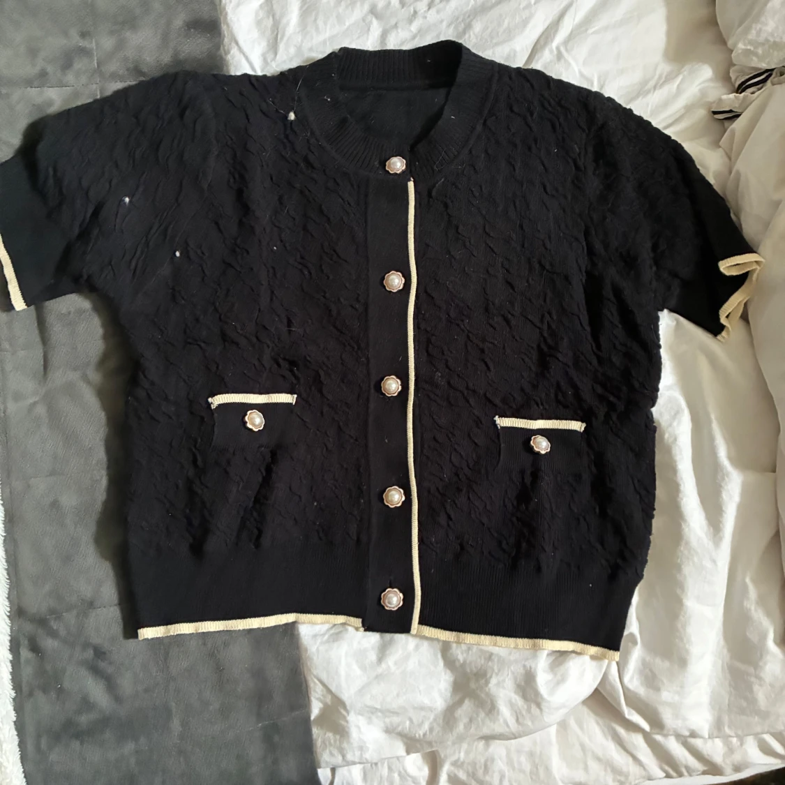 Svart kofta med pärlknappar