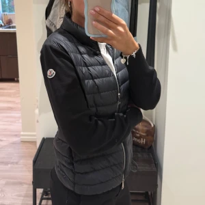 Svart Moncler cardigan - Svart Cardigan från Moncler. Jackan har dragkedja framtill och Moncler-logga på ena ärmen. Perfekt för dig som vill ha en stilren och somrig look. Säljer då den är för stor och inte kommer till användning💗 Vill blir av med den så pris går att diskutera.