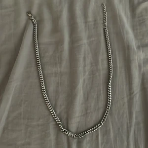 Kedjehalsband i silverfärg - Stilrent halsband med grov kedja i silverfärg. Klassisk design med täta länkar som ger en cool och modern vibe. Perfekt accessoar för att lyfta din outfit och funkar lika bra till streetwear som till mer dressade looks.