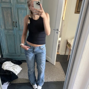 Ljusblå jeans med slitningar - Säljer ett par klassiska jeans i ljusblå denim med snygga slitningar på låren och knäna. Jeansen har utsvängd passform, låg midja och femficksdesign. Perfekta för en avslappnad och trendig look. Sytt om dem själv och gjort hålen själv❤️