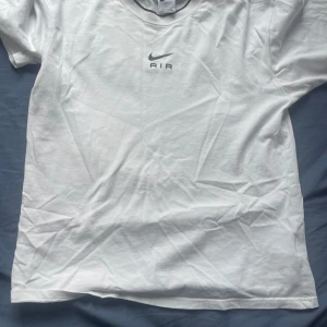 Vit Nike Air t-shirt i bomull - Fräsch vit t-shirt från Nike med klassisk Air-logga och svart swoosh på bröstet. T-shirten är i mjuk bomull, har rund halsringning och korta ärmar. 