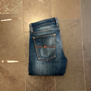 Nudie jeans 30/32 - Tja, säljer nu dessa tvär snygga nudie jeansen. Jeansen är 30/32 och är slim fit och sitter snyggt på benen. Jeansen är i bra skick och har mycket kvar att ge. Hör av dig vid minsta fundering, pris ej hugget i sten. 