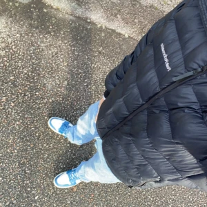 Svart dunjacka från Peak Performance - Säljer en svart dunjacka från Peak Performance med diskret logga på bröstet. Jackan har dragkedja framtill, quiltad design och hög krage. Perfekt för kalla dagar och riktigt skön att bära. Passar dig som gillar en stilren och sportig look.