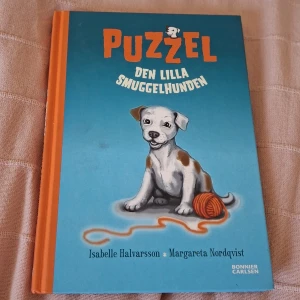 Puzzel: Den lilla smuggelhunden - En charmig bok om den lilla hunden Puzzel, perfekt för unga djurälskare. Färgglada illustrationer och en söt berättelse gör den här boken till ett måste för dig som gillar hundar och spännande äventyr.