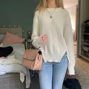 Vit stickad tröja - Fin stickad tröja, används några gånger men väl omhändertagan. Detalj av dragkedja som går att ha öppen och stängt. 