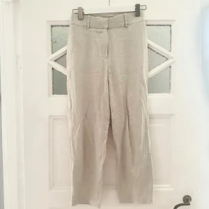 Beige linnebyxor från H&M - Ljusbeige byxa i linnenblend. Endast använd 1-2ggr. Stretchig midja och med fickor. Storlek 36