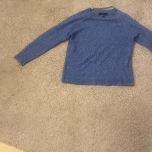 Blå stickad tröja från vero Moda  - Mysig blå stickad tröja från vero Moda med rund halsringning och långa ärmar. Perfekt för kyliga dagar och enkel att matcha med jeans eller kjol. Tröjan har en klassisk passform och ribbade muddar vid ärmslut och nederkant.