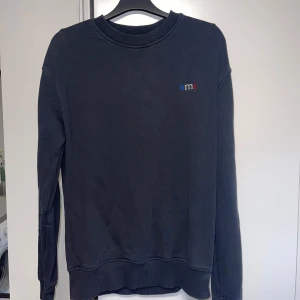 Ami Paris sweatshirt - Sweatshirt från märket ami Paris, tröjan är i ett fint skick förutom defekten vid handleden (se bild 3). Detta går att fixa genom att sy igen hålet. Storlek S