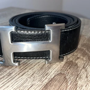 Svart bälte med H - Nästan helt nytt. Har en liten repa vid slutet av bältet. Pris kan diskuteras!