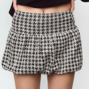 Svartvit rutig kortkjol Zara - Supersnygg kortkjol från Zara i svartvitt rutigt mönster. Kjolen har en ballongliknande form som ger en cool siluett. Tillverkad i ett grovt, vävt material som känns både trendigt och bekvämt. Skriv vid fler bilder💞