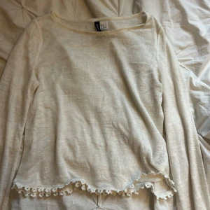 Beige/vit långärmad topp med spetskant - Supersöt beige/vit långärmad topp från hm med rund halsringning och dekorativ spetskant nertill. Tunt och lätt material som passar perfekt till lager-på-lager eller som den är. Enkel att styla med både jeans och kjol.