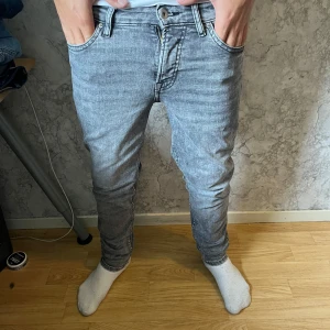 Grå slim jeans från Vaillent W29 L30 - Säljer ett par grå slim fit jeans från Vaillent i storlek W29 L30. Jeansen har klassisk femficksdesign, låg midja och smal passform. Materialet är mjukt denim och färgen är ljusgrå med tvättad look. Perfekta för dig som gillar en clean och modern stil. Pris ej hugget i sten vid snabb affär. hör av dig vid minsta fundering!