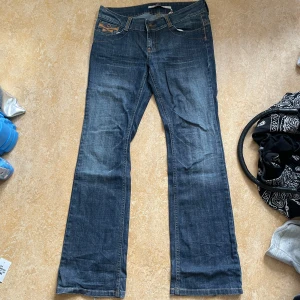Blå bootcut jeans från Only - Snygga blå jeans från Only med bootcut passform och klassiska kontrastsömmar. Jeansen har fem fickor, nitar vid bakfickorna och en liten Only Jeans-logga. Perfekta för dig som gillar en tidlös och avslappnad stil.