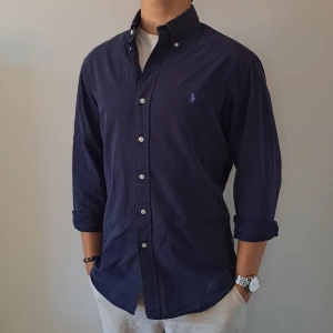 Marinblå Ralph Lauren Skjorta - Stl M, Slim Fit - Hej säljer en fin Ralph Lauren skjorta I färgen Marinblå, Perfekt till sommaren! 🏖🏝 | Skick: 9/10 | Stl: M, Slim fit | Han på bilden är 172cm | Fraktar spårbart med Instabox eller Postnord | Mvh Galgen 🤗
