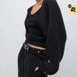 Svart stickad kofta med loose fit - Snygg svart stickad kofta med loose fit och långa ärmar. Koftan är öppen framtill och har en enkel, stilren design som passar perfekt till lager-på-lager. Mjuk och skön att bära, perfekt för kyligare dagar.