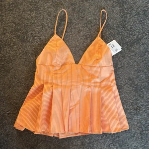 Randig orange linnetopp från Zara - Superfin orange linnetopp från Zara med tunna axelband och vita smala ränder. Helt oanvänd så snygg!!!